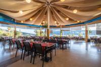 una sala da pranzo con tavoli, sedie e finestre di Bodrum Holiday Resort & Spa a Bodrum City