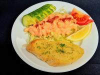 un plato blanco de comida con pescado y verduras en Supreme Inn Boston, en Swineshead