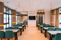 uma sala de aula com mesas e cadeiras e um ecrã em Rivera resort and wellness center em Kodanad