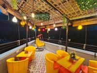 a restaurant with yellow chairs and tables on a balcony at Tathastu Stay in Dehradun