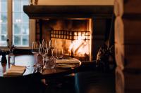 Una mesa con copas de vino y una chimenea. en Storfjord Hotel, en Skodje