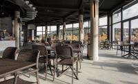 Un restaurante con mesas, sillas y ventanas. en Czarna Perła Apartamenty z bezpłatnym basenem Czarna Góra Resort, en Sienna