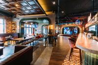 伦敦德里Holiday Inn Express - Derry - Londonderry by IHG的一家有桌椅和酒吧的餐厅