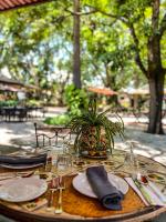 a table with plates and a potted plant on it at Hacienda El Carmen Hotel & Spa in Portes Gil