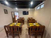 Un comedor con mesas y sillas y un televisor. en Evara Hotel & Apartment, en Katmandú