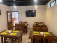 aula con mesas y sillas de madera y TV en Evara Hotel & Apartment, en Katmandú