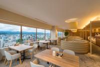 a restaurant with tables and chairs and large windows at Art Hotel Asahikawa in Asahikawa