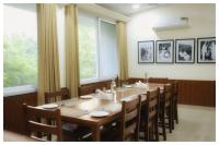 uma sala de jantar com uma grande mesa de madeira e cadeiras em Arogyadham Swasthya Kutir em Chitrakoot