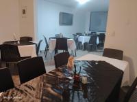 uma sala de jantar com mesas e cadeiras e uma mesa com toalha de mesa em Gran Hotel Coral em Popayan