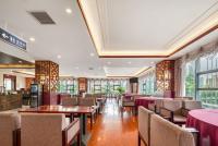 uma sala de jantar com mesas, cadeiras e janelas em 青岛机场富华酒店 em Qingdao