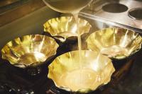 a group of foil pans are being filled with liquid at ご当地ラーメン食べ放題 "The RAMEN HOTEL" -京都嵐山- in Kyoto