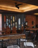 a restaurant with wooden tables and chairs and a wall with masks at Eliseos Bed & Kitchen in San Juan