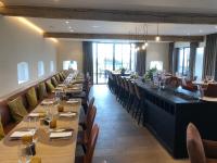 a dining room with long tables and chairs at De Kruishoeve in De Haan