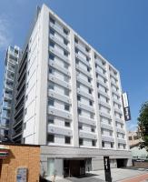 Un gran edificio blanco con balcones. en Dormy Inn Nagano, en Nagano