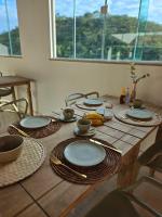 een houten tafel met borden en kommen erop bij Villa Sol hospedaria in Paty do Alferes