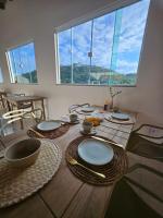 een houten tafel met borden en kommen erop bij Villa Sol hospedaria in Paty do Alferes