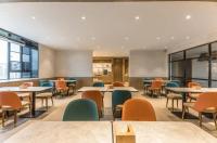 a dining room with tables and chairs at Hanting Premium Hotel Shanghai West Yingao Road Subway Station in Baoshan