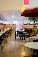 默恩达尔Best Western Plus Åby Hotel的空餐厅,配有桌椅和雨伞