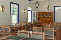 een eetkamer met tafels en stoelen en ramen bij Quinta das Águas Hotel in Itapira