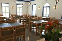 een kamer met tafels, stoelen en ramen bij Quinta das Águas Hotel in Itapira