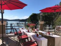 a table with chairs and red umbrellas on a patio at Poets Cove Resort & Spa in Bedwell Harbour