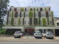 dos coches estacionados frente a un edificio con plantas en Vine and Canopy, en Olóngapo