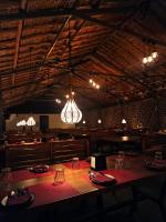 ハンピにあるThe Hampi Cafeの大きな木製のテーブルと照明のあるダイニングルーム