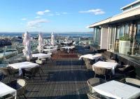 uma varanda com mesas e cadeiras num edifício em Luxury 2BR Sky Suite City Views & Prime Location na Cidade do Cabo