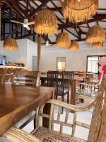卢纳将军城Inbox Siargao Resort的有桌椅和吊灯的餐厅