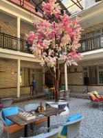 un árbol en medio de una habitación con mesas y sillas en HOM House of MannMauji Riverside kasol, en Kasol