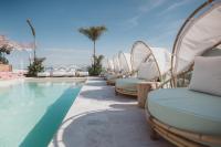 プラヤ・デル・カルメンにあるMARQUEE Playa Hotelのスイミングプールの横に長椅子が並ぶ