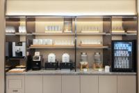 Lung WaにあるJI Hotel Shenzhen Guanlan Huawei Jiulongshanのボトルと棚が置かれたコーヒーショップのカウンター