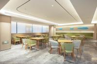 Lung WaにあるJI Hotel Shenzhen Guanlan Huawei Jiulongshanのテーブルと椅子のあるダイニングルーム