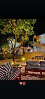 two benches and a tree in a park at night at Leyla Eco Resort Queen Suites in Luxor