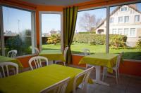 a room with two tables and a large window at Hotel au Moyne De Saire in Réville