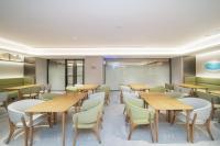 un restaurante con mesas y sillas de madera en JI Hotel Shenzhen Convention & Exhibition Center Gangxia Subway Station, en Shenzhen