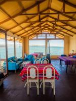 普诺Uros Titicaca Kurmi lodge的配有桌椅的海洋客房
