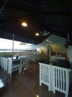 een restaurant met witte tafels en stoelen en een plafond bij Ice Cloud Munnar Pool Resort in Munnar