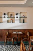 um restaurante com mesas, cadeiras e prateleiras na parede em Abode Jaipur em Jaipur