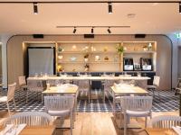 uma sala de jantar com mesas e cadeiras em Ibis Darwin Airport Hotel em Darwin