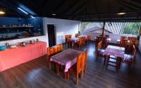 ein Restaurant mit Tischen und Stühlen und eine Bar in der Unterkunft Rendezvous Jungle Resort in Sultan Bathery