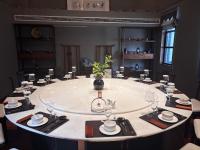 a large table in a room with a round table with glasses at 成都释玥森林酒店 in Chengdu