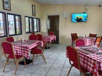 un restaurante con mesas y sillas rojas y blancas a cuadros en Villas Palmerola Comayagua, en El Coquito