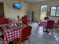 un restaurante con mesas y sillas rojas y blancas a cuadros en Villas Palmerola Comayagua, en El Coquito