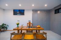 Un comedor con mesa y sillas de madera. en Blue Sea Hotel, en Dali