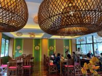 mensen zitten aan tafels in een restaurant met grote kroonluchters bij Mina Resort and Spa in Loei