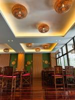 een restaurant met houten tafels en stoelen en ramen bij Mina Resort and Spa in Loei