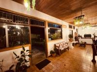 sala de estar con ventanas grandes y sofá en Habitación doble, Hotel Aurora Inn, Nuevo Arenal, en Nuevo Arenal