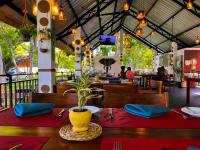 a restaurant with a table with red table cloths and a plant at Grand Toscana in Udawalawe