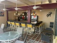 un bar en un restaurante con sillas y mesa en The Frederiksted Hotel, en Frederiksted